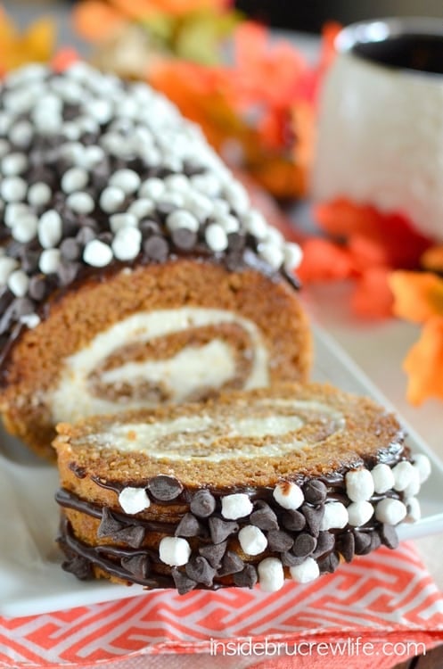 S'mores Pumpkin Roll - chocolate drizzles and marshmallow frosting adds a fun twist to the classic pumpkin roll. Easy recipe to make for dinners this fall. #pumpkin #cakeroll #fall #smores #thanksgiving