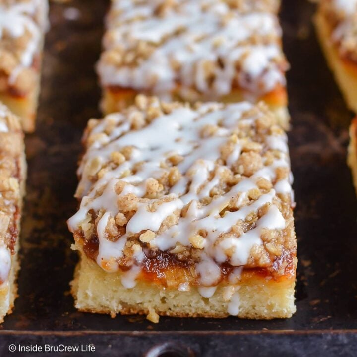 Squares of coffee cake on a dark tray.