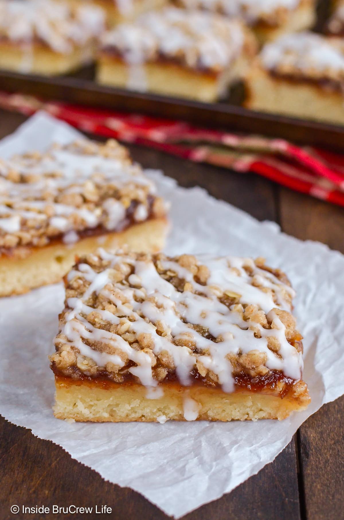 Two squares of apple coffee cake on parchment paper.