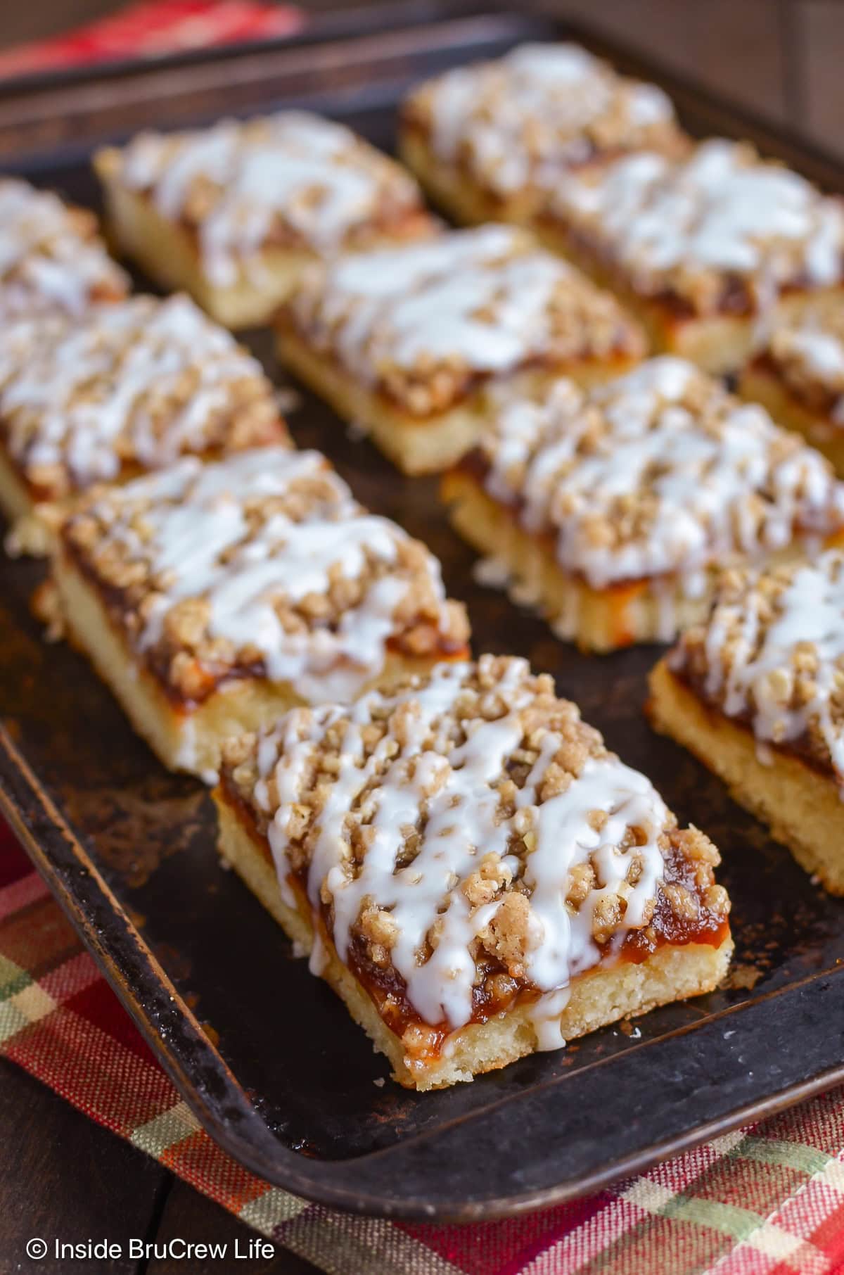 Coffee cake squares with apple butter and crumble topping on a cookie sheet.