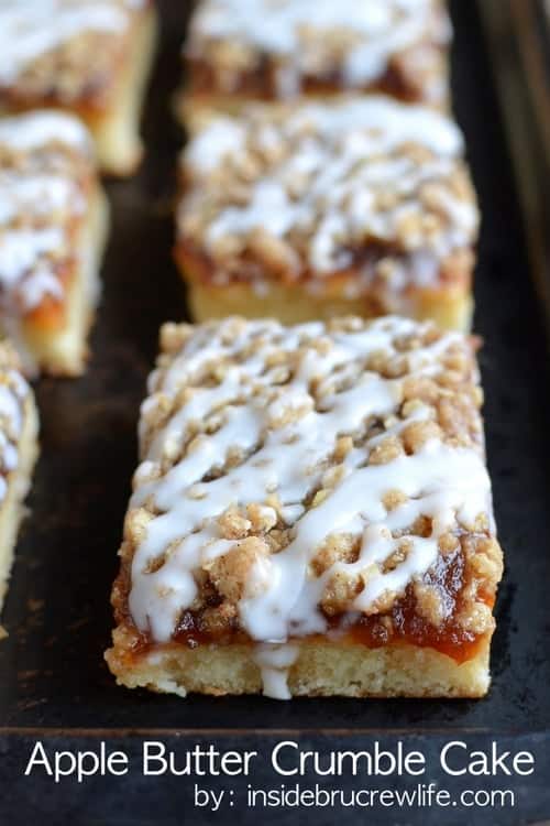 Apple Butter Crumble Cake - close up of a square of apple butter coffee cake drizzled with glaze on a black sheet pan