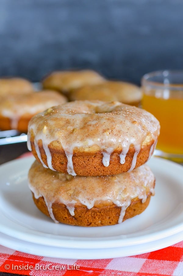 Two baked cinnamon apple donuts stacked on top of each other on a white plate