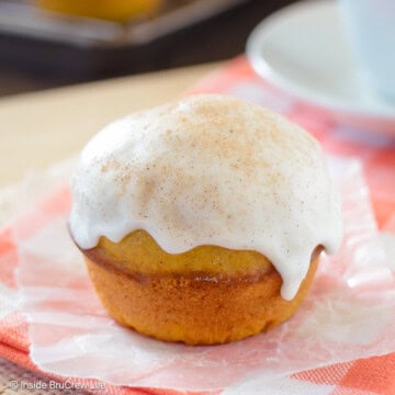 A glazed pumpkin muffin on an orange towel.