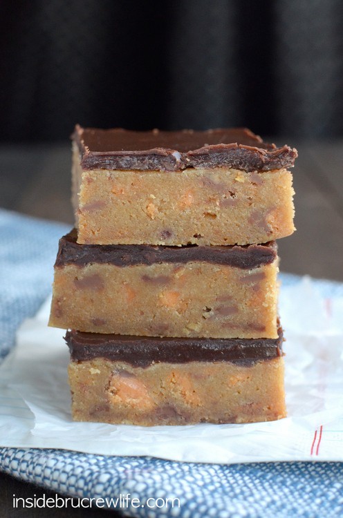 The rich decadent blonde brownies are full of Butterfinger candy bar chunks and topped with chocolate.  Good luck only eating one!