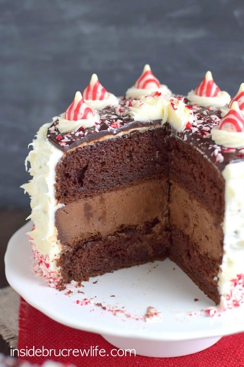 Candy Cane Chocolate Cheesecake Cake - chocolate cheesecake and chocolate cake layers get covered with peppermint frosting, candy cane chunks, and more chocolate! Perfect dessert for holiday parties!