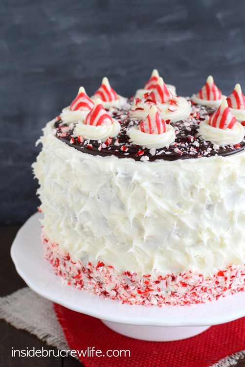 Candy Cane Chocolate Cheesecake Cake - fluffy peppermint frosting and candy cane chunks cover the layers of chocolate cake and cheesecake!  Such a great cake for holiday parties!