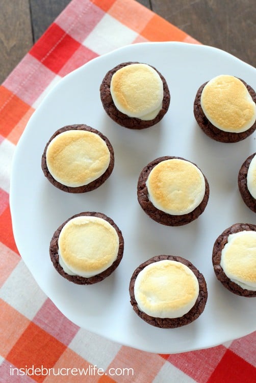 Mini brownie bites stuffed with peanut butter cups and topped with a toasted marshmallow for a fun s'mores twist!