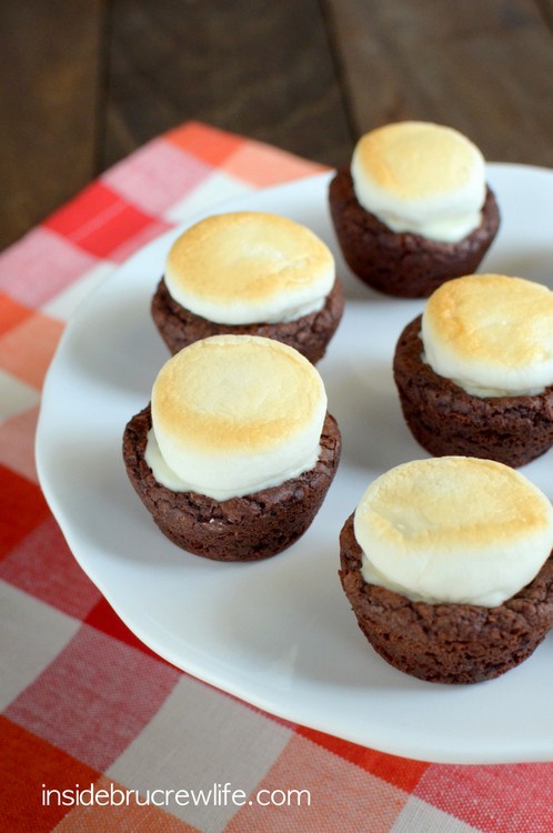 Mini brownie bites stuffed with peanut butter cups and topped with a toasted marshmallow for a fun s'mores twist!