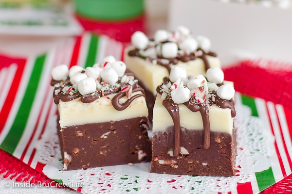 Three squares of candy cane hot chocolate fudge on red and green papers.