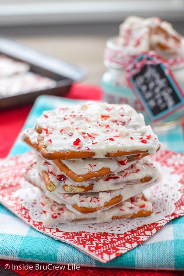 A stack of candy cane pretzel bark squares on a red and teal towel