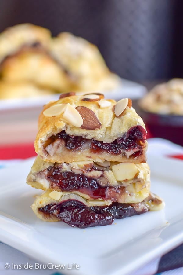 A white plate stacked with a cherry cheese pastry.