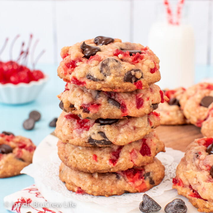 A stack of chocolate chip cherry cookies on a round board.