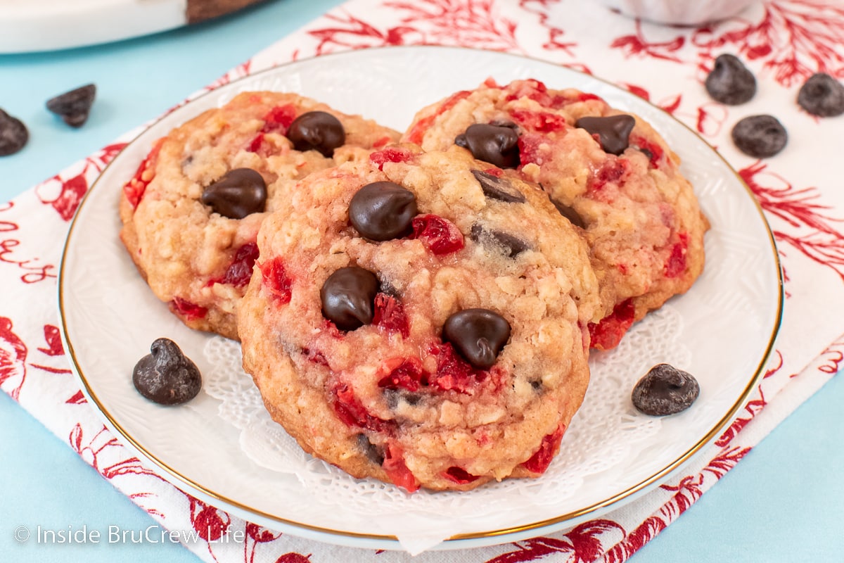Three cherry chip cookies on a white plate.