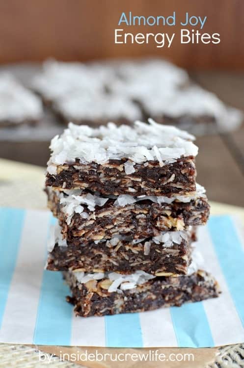 A white and blue paper with a stack of four almond joy energy bites stacked on it