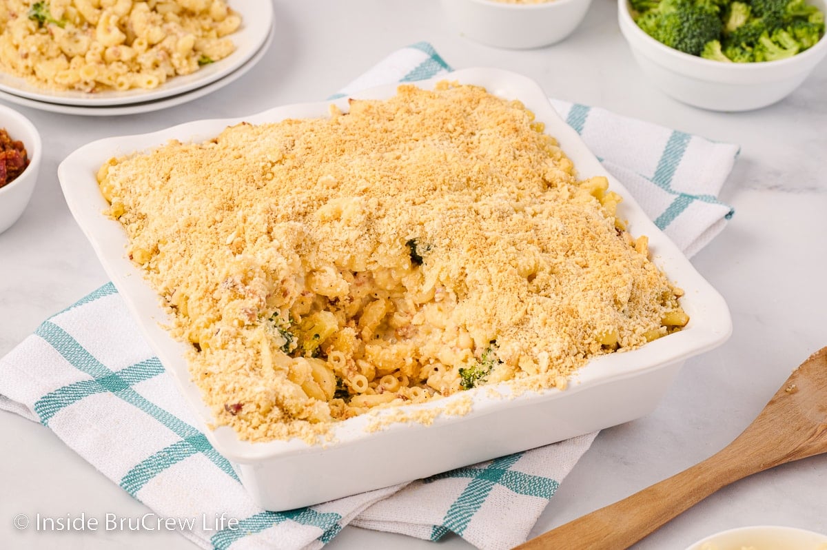 A square white pan filled with baked macaroni and cheese.