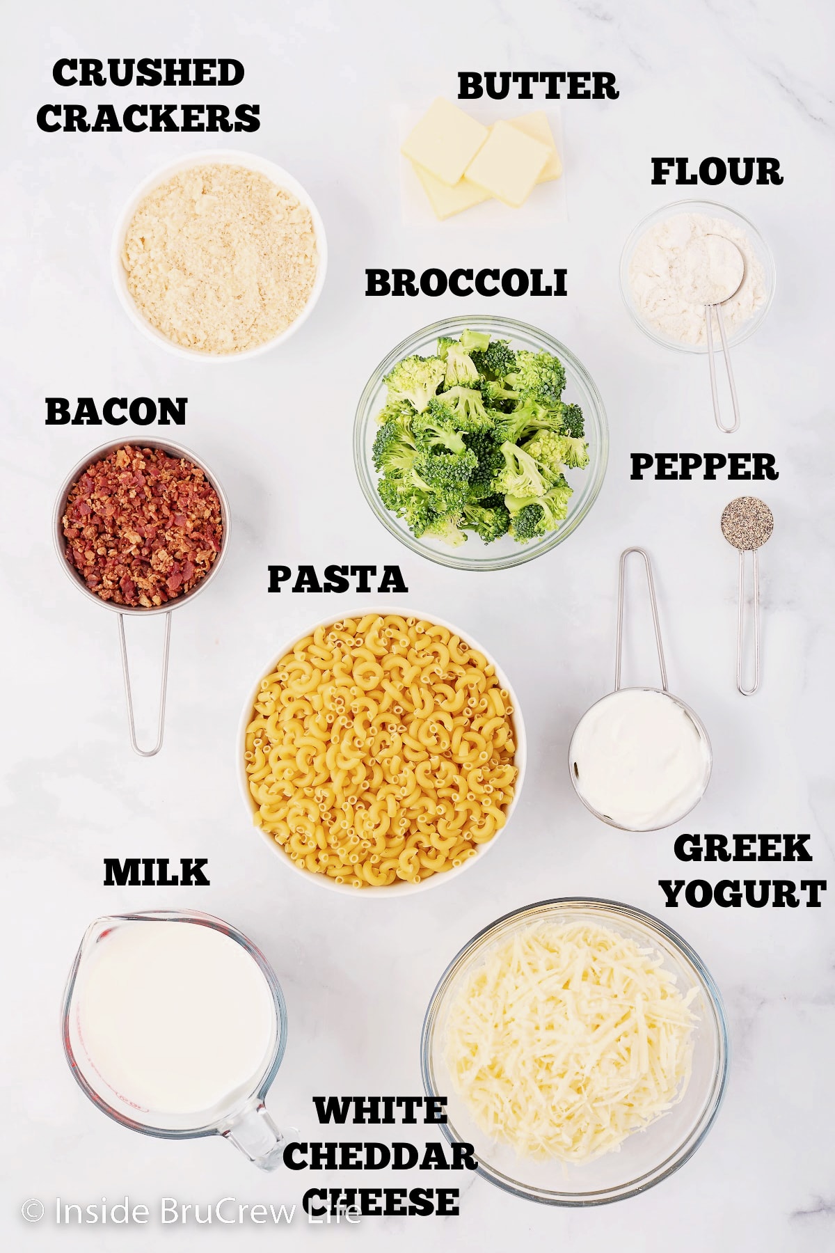 A white board with bowls of ingredients needed to make mac and cheese.