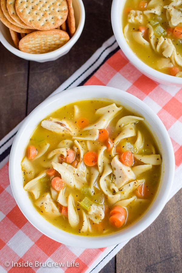 A white bowl filled with chicken noodle soup.