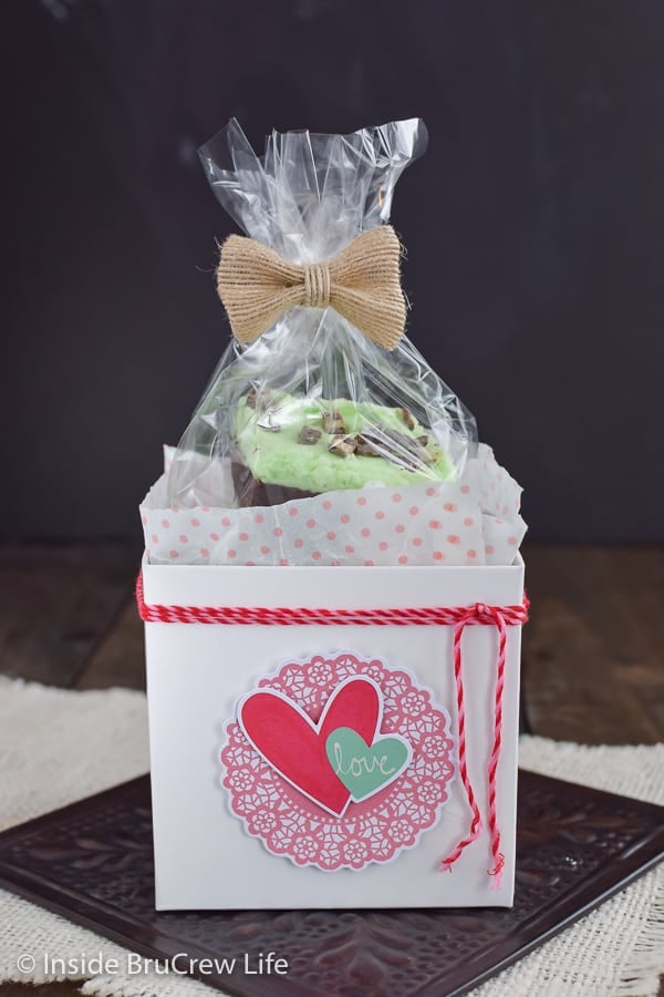 A white box with pink hearts on it filled with chocolate mint sugar cookie bars