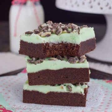 A stack of three chocolate mint sugar cookie bars stacked on a white doily