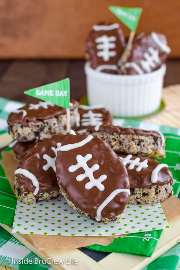 A stack of football shaped rice krispie treats on a board.