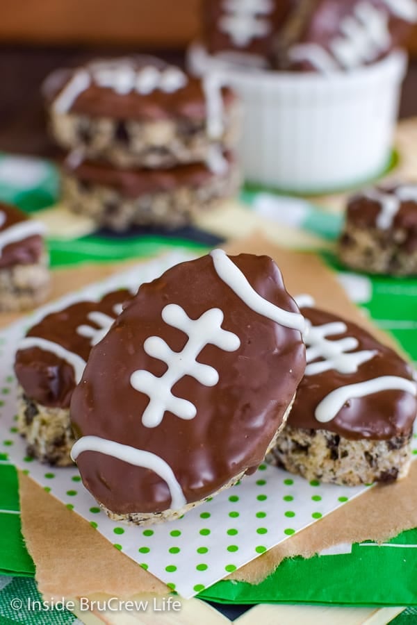 Football shaped rice krispie treats on a green and white napkin.