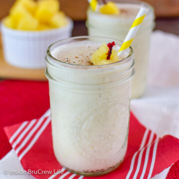 A small clear glass filled with a vanilla pineapple smoothie on a red napkin