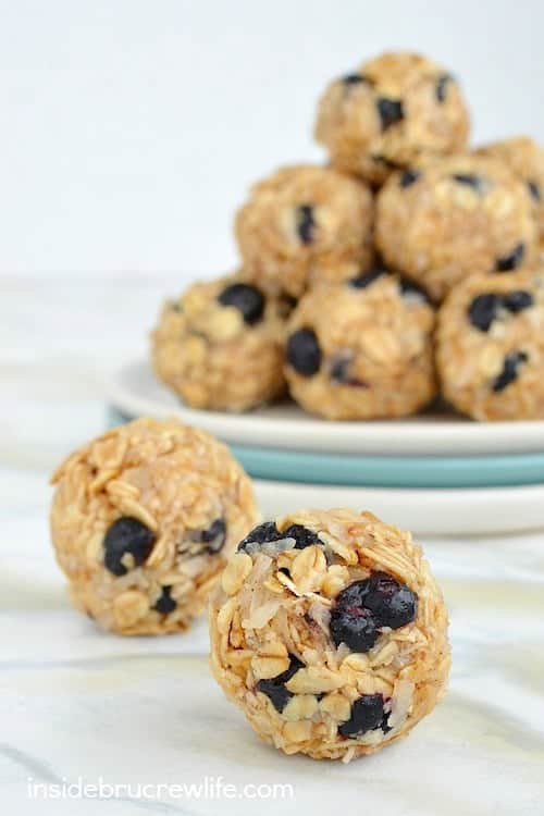 A plate of blueberry coconut granola bites with two bites in front of the plate