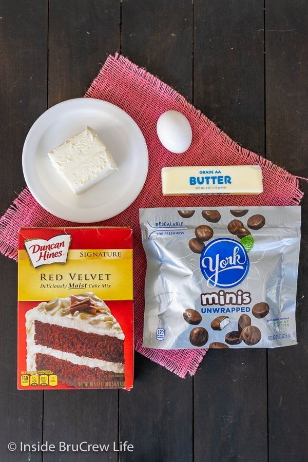 A dark board with ingredients to make red velvet peppermint pattie cookies