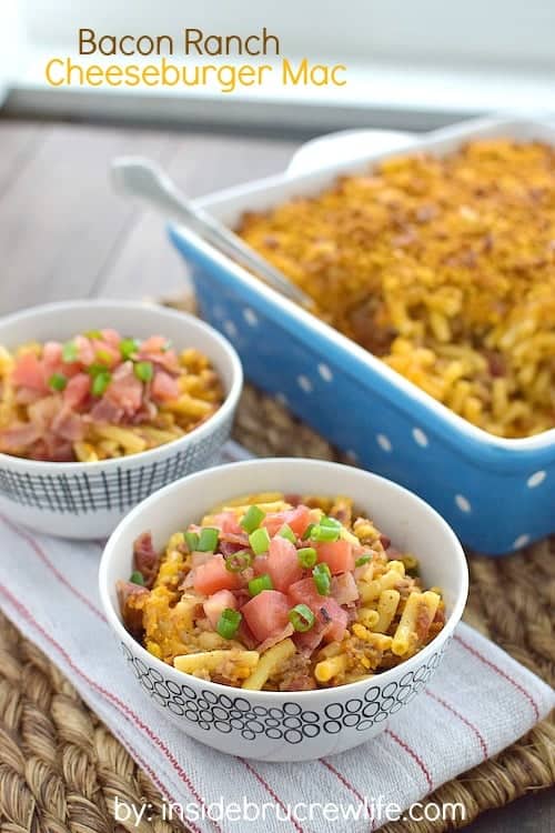 Two bowls of mac and cheese topped with bacon and tomatoes.