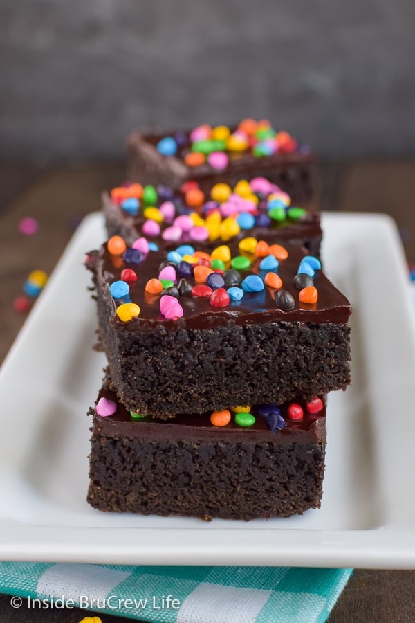 Frosted Rainbow Chip Brownies - chocolate frosting and colorful sprinkles make these homemade brownies taste so good. Great copycat recipe for cosmic brownies that are perfect for lunch boxes or bake sales.