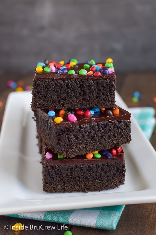 Frosted Rainbow Chip Brownies - these dark chocolate homemade brownies are topped with chocolate frosting and rainbow chips making them the perfect copycat recipe for cosmic brownies. Make this easy recipe for bake sales or lunch box treats.
