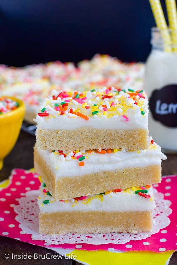 Three frosted lemon sugar cookie bars stacked on top of each other.