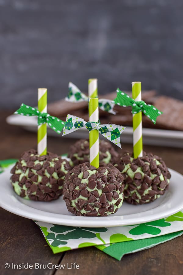 4 mint cream cheese balls covered in mini chocolate chips on a white plate.