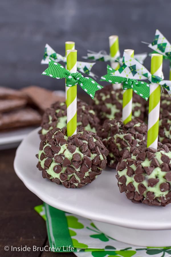 Green mint cream cheese balls covered in mini chocolate chips on a white plate.