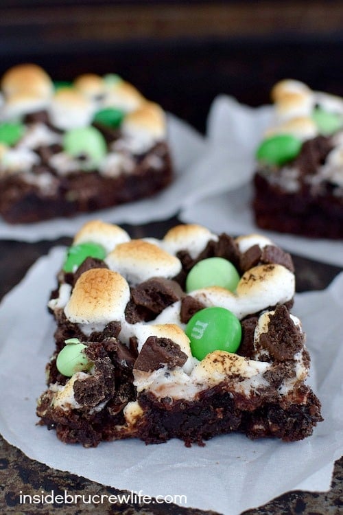 Chocolate brownies topped with toasted marshmallows, chocolate chips and green M&M's.