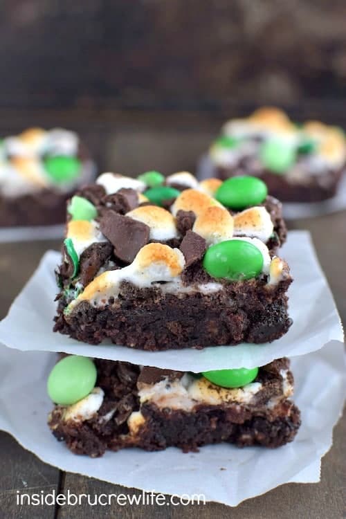 2 brownies topped with toasted marshmallows, chocolate chips and green M&M's.