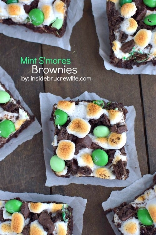 Multiple chocolate brownies topped with toasted marshmallows, chocolate chips and green M&M's.