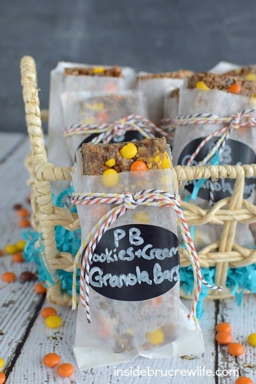 A peanut butter cookies and cream granola bar packaged in a white bag with a label and twine standing by a basket