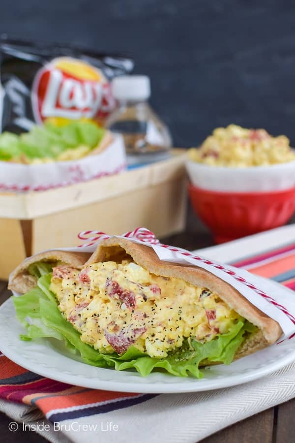 A pita pocket filled with egg salad on a plate.