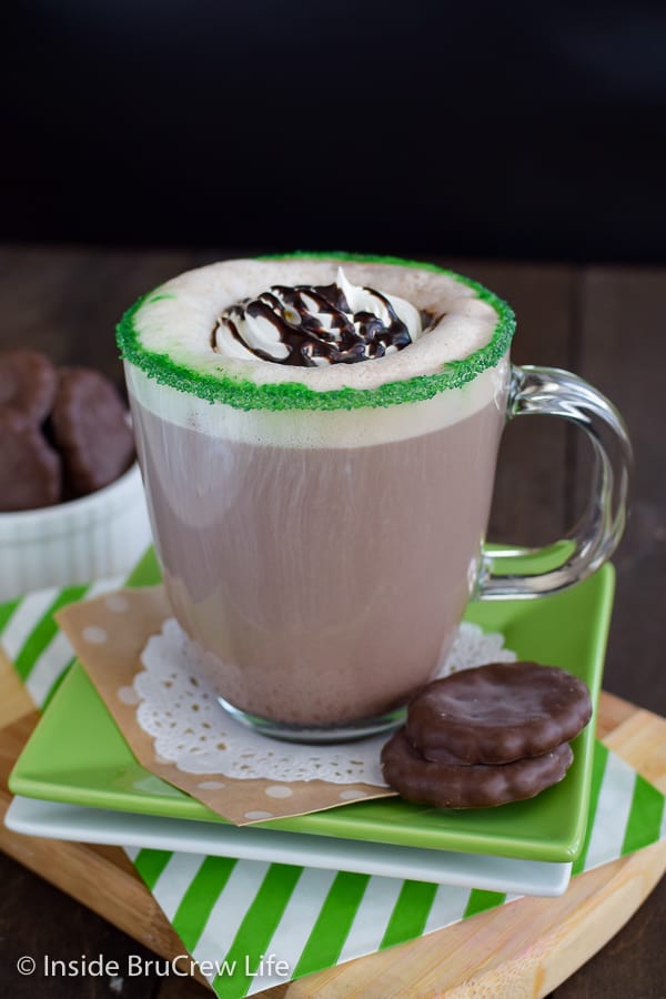 A chocolate mint latte on a green plate with a green sugar rim around the top of the cup.