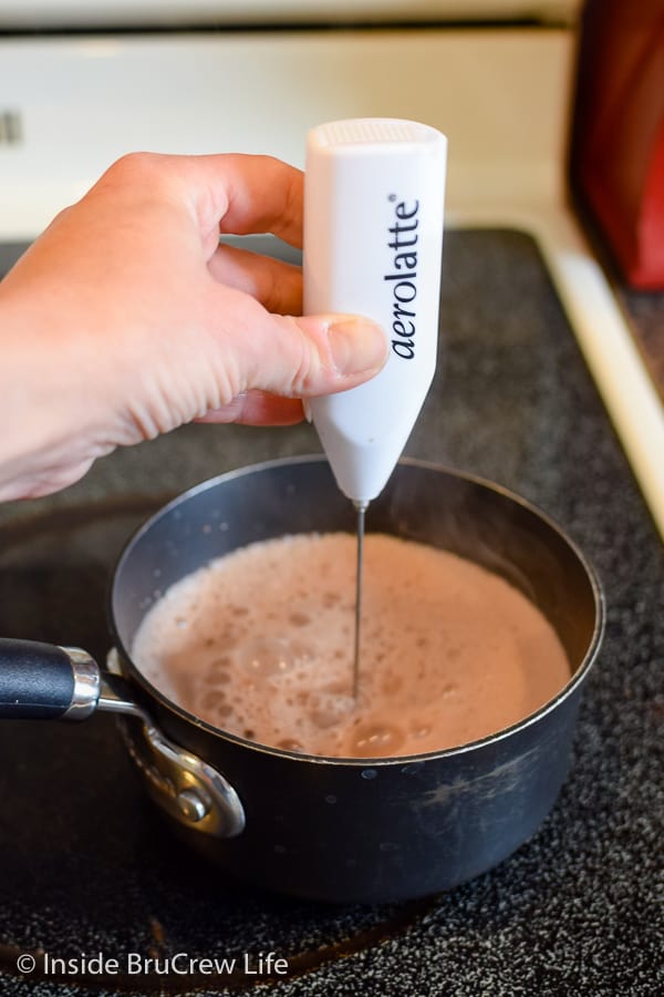 Aerolatte frothing milk in a saucepan.