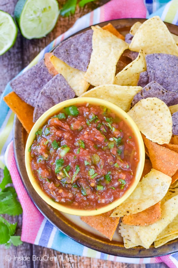 Overhead picture of a yellow bowl filled with an easy homemade salsa and chips all around the bowl