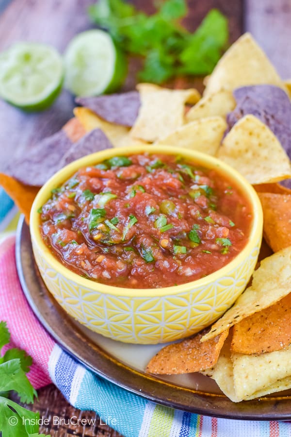 A plate with a tortillas chips and a yellow bowl filled with an easy salsa recipe