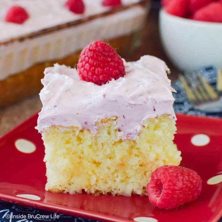 A slice of hazelnut raspberry cake on a red polkadot plate.