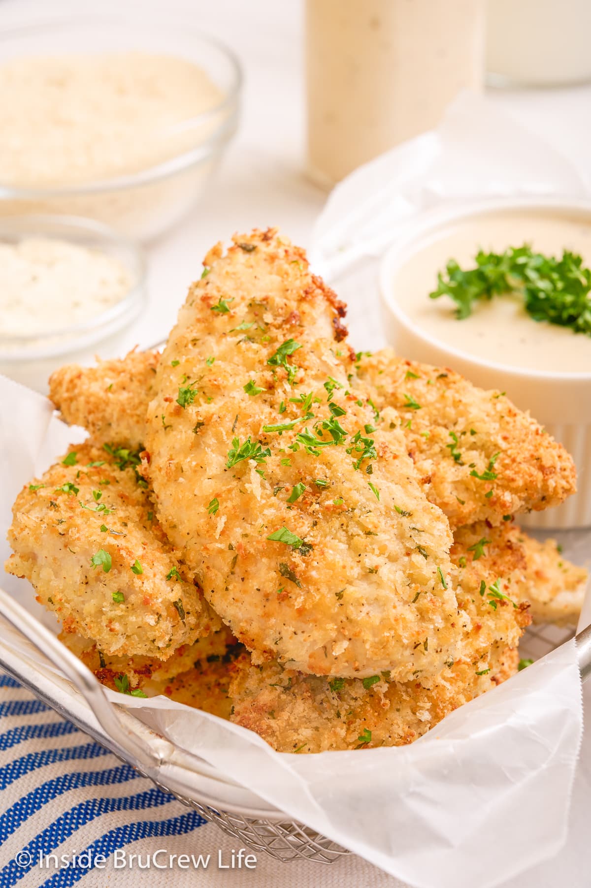 Breaded chicken strips in a wire basket.