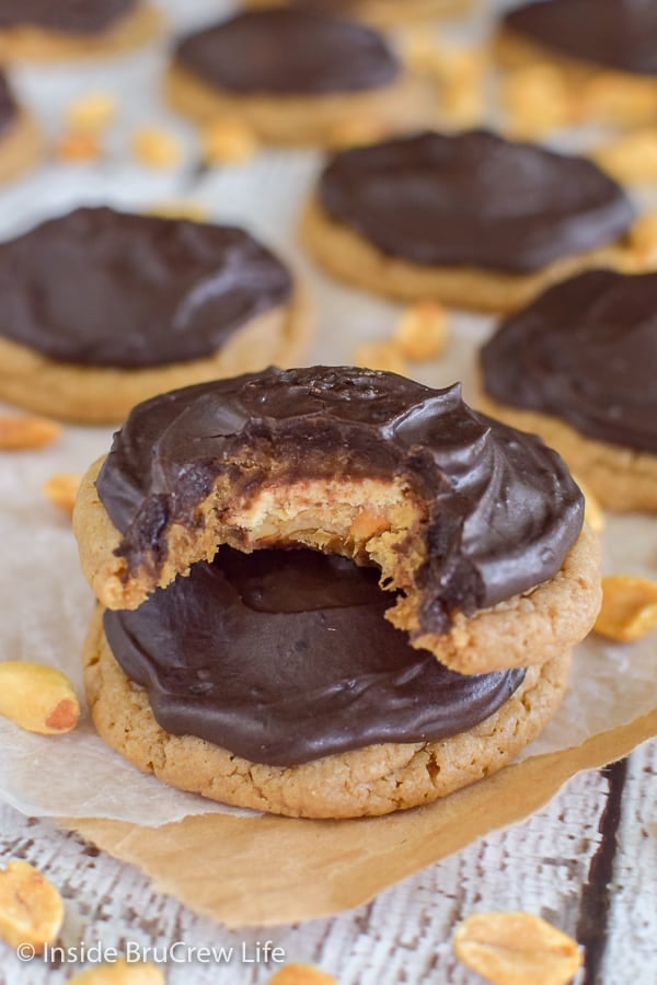 Caramel Peanut Butter Snickers Cookies - a hidden candy bar and chocolate frosting add so much fun to these easy cake mix cookies. Make this easy recipe for your cookie jar this week.