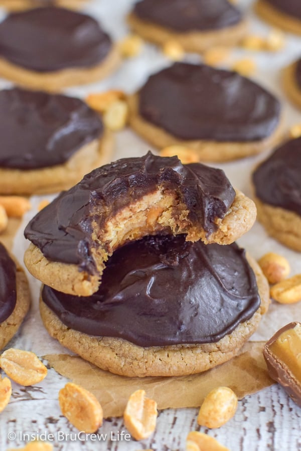 Caramel Peanut Butter Snickers Cookies - a soft cake mix cookie stuffed with a candy bar and topped with chocolate frosting make a great treat. Easy recipe to make for dessert.