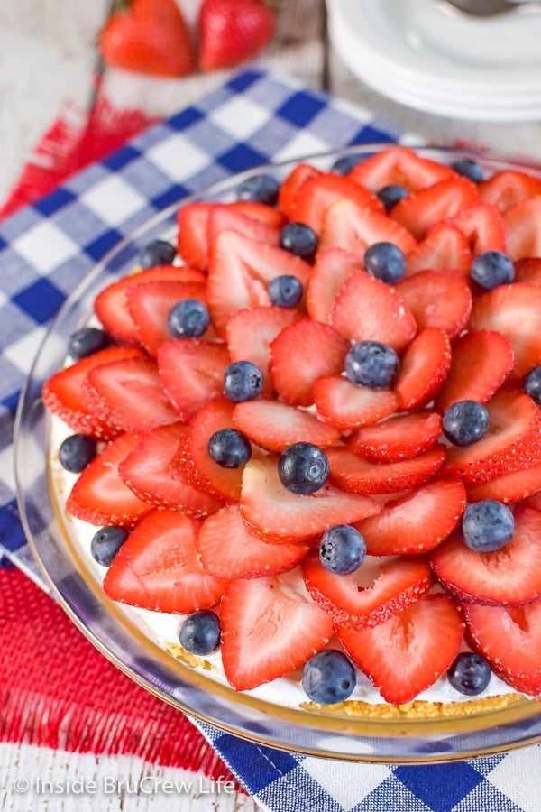 A close up picture of the left side of a strawberry lemon cream pie in a pie plate