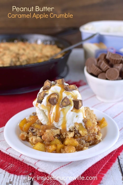 A bowl of apple crisp topped with ice cream and peanut butter cups.