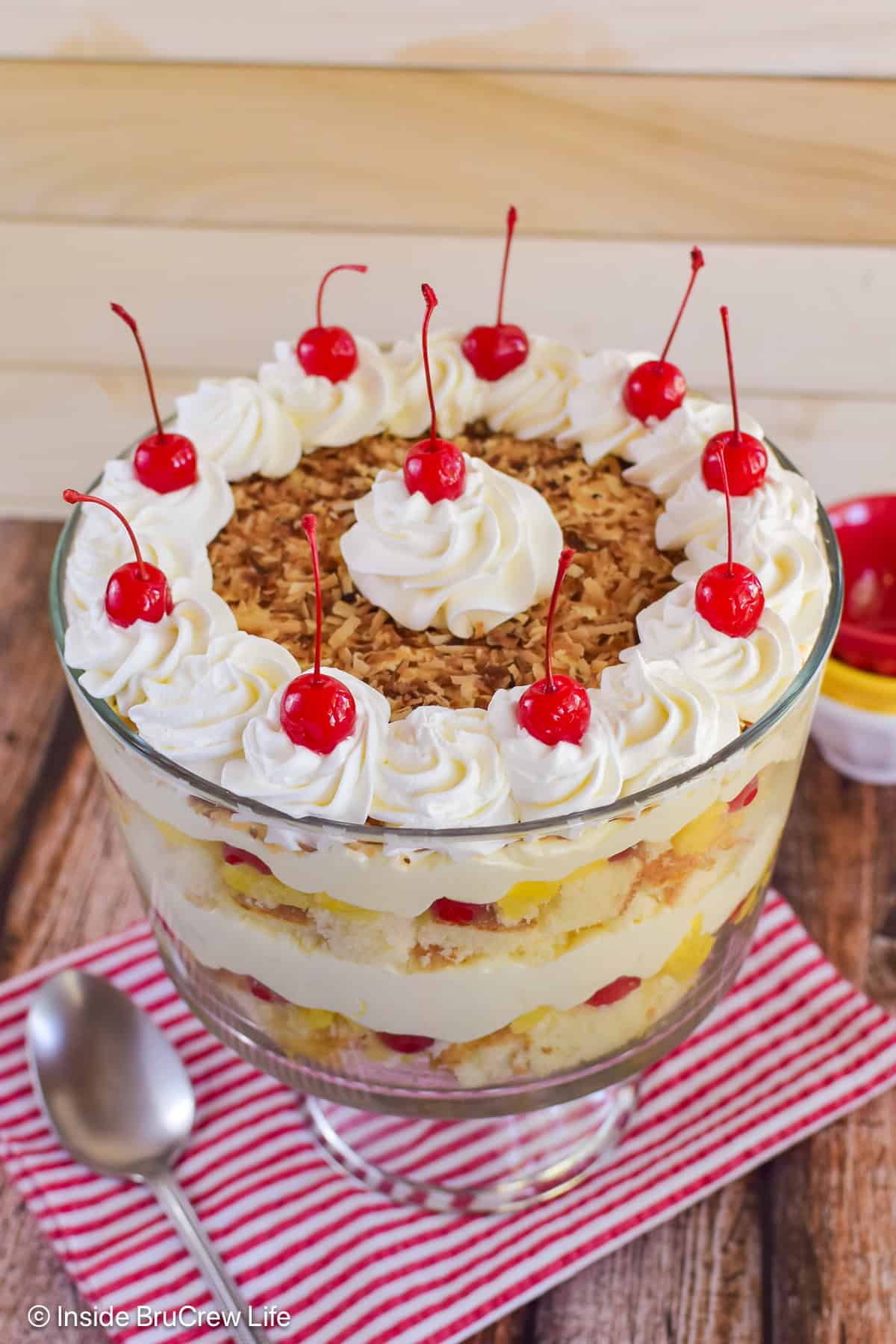A pineapple and coconut trifle layered in a clear bowl.